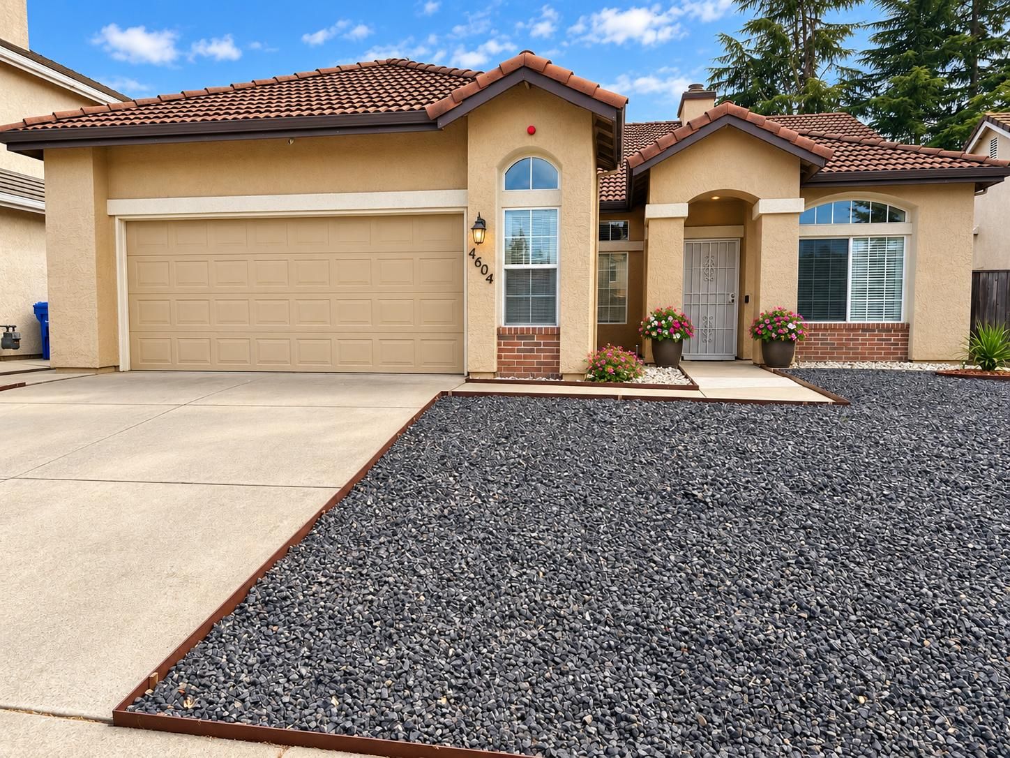 The front of Kelechi Care Home, a single-storey house with a tiled roof, planted pots and a paved path to the door